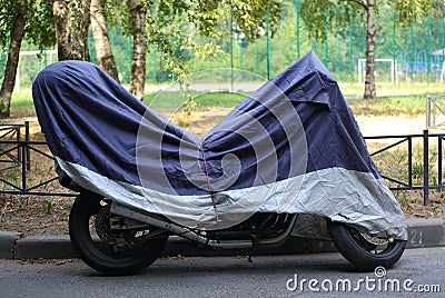 Motorcycle is covered with a cover Editorial Stock Photo