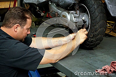 Motorcycle mechanic fixing rear tire Editorial Stock Photo