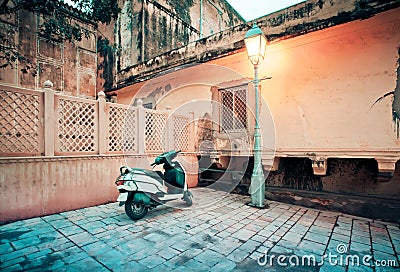 Motorcycle parked near lamppost in old city street Stock Photo