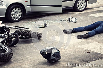 Motorcyclist helmet and motorbike on the street after collision Stock Photo