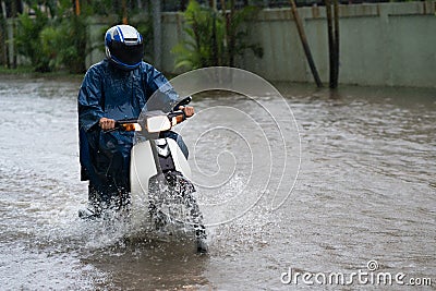 A motorcyclist rides along a flooded street in Hanoi city, Vietnam Stock Photo