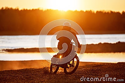Motorcyclist on electric enduro motorbike in sunset light Stock Photo
