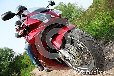 Motorcyclist standing on country road, bottom view Stock Photo