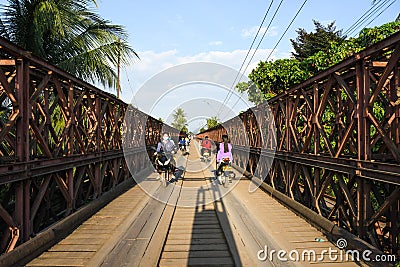 Motorcyclists and Cyclists crossing old bridge across Mekong River Editorial Stock Photo