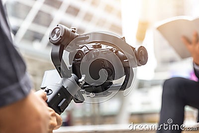 Motorized gimbal, videographer using dslr camera anti shake tool Stock Photo