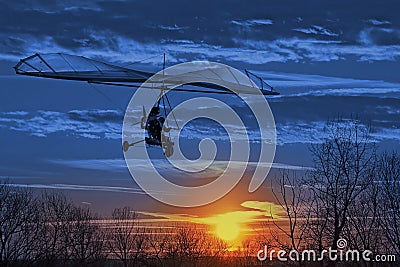 The motorized hang glider fly in the sunset. Classic Blue 2020 year color Stock Photo