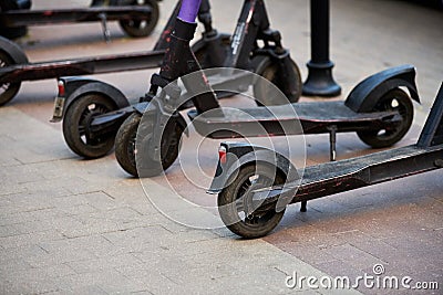 Motorized scooter parking for hourly rent on sidewalk street, vehicle for fast movement around town Stock Photo