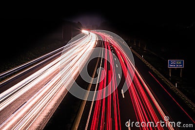 Motorway at night with fast moving cars Stock Photo