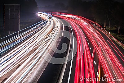 Motorway at night with fast moving cars Stock Photo