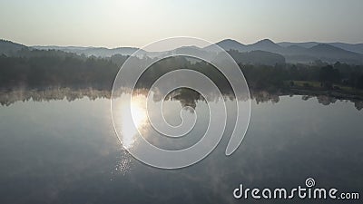 Mouche aérienne cinématographique par un brouillard de matin au-dessus d'un lac de montagne Lever de soleil brumeux en montagnes banque de vidéos Mouche aérienne cinématographique par un brouillard de matin au-dessus d'un lac de montagne Lever de soleil brumeux en montagnes banque de vidéos