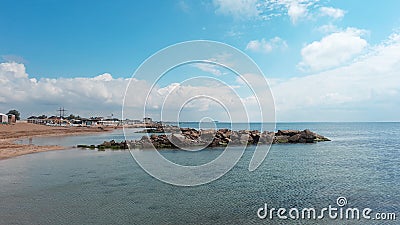 Mound of large stones on the beach. Cobblestones on the sandy shore of the Black Sea in the Crimea. Stock Photo