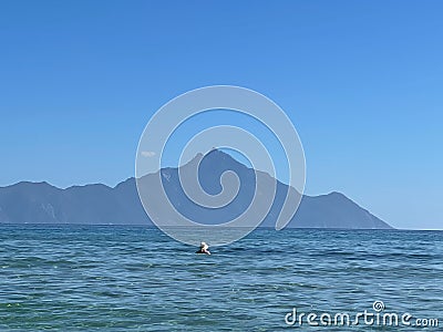 View from the beach in Sarti, with crystal clear, blue water and Mount Athos in the background Stock Photo