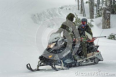 Snowmobile gives snowboarder a lift Editorial Stock Photo