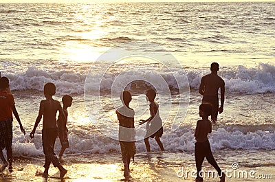 Mount Lavinia Beach. Colombo, Sri Lanka. 05th March 2016. Silhouette of group of boys at the beach with the sunset background Editorial Stock Photo