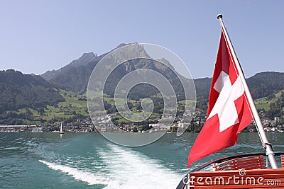 Mount Pilatus with Swiss Flag and wake of boat. Stock Photo