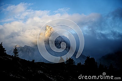 Mount Sass de Stria at sunrise, blue sky with clouds and fog, Falzarego pass, Dolomites, Veneto, Italy Stock Photo