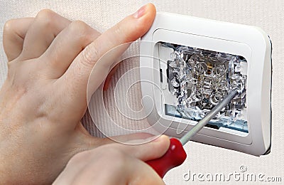 Mount wall light switch, close-up of human hand with screwdriver Stock Photo