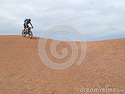 Mountain biker riding downhill the famous Slickrock trail, Moab, USA Stock Photo