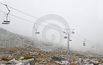 Mountain cableway chairlift in clouds and fog Stock Photo