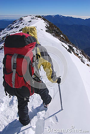 Mountain climber on snowy summit Stock Photo