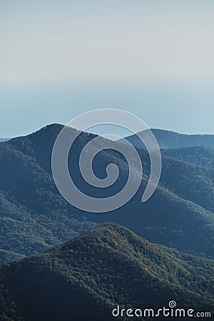 Vertical nature screensaver. Minimalism. Mountain forests and sea can be seen on horizon in distance. Mountain view of forest and Stock Photo