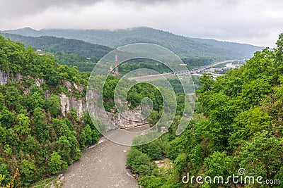 Mountain gorge with a river below. Green mountains in the fog Stock Photo