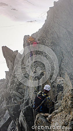 Mountain guide and client heading towards a high alpine summit on a foggy day Editorial Stock Photo