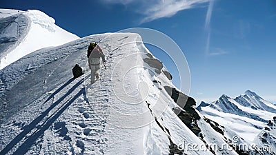 Mountain guide and client on a steep north face slope heading towards the summit with a great view of the surrounding mountain lan Editorial Stock Photo