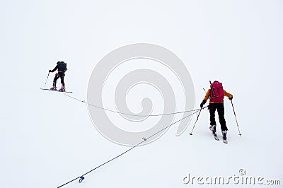 Mountain guide and clients on a glacier during a whiteout Stock Photo