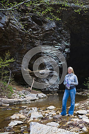 Mountain Hiker by a Cave and Creek Stock Photo