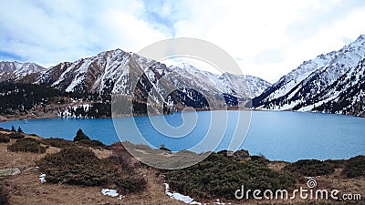 A mountain lake with blue water in winter Stock Photo