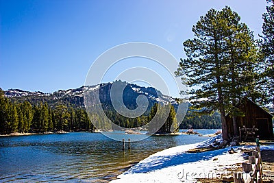 Mountain Lake Shoreline With Snow Melting In Springtime Stock Photo