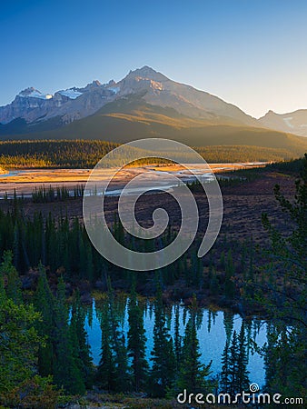 Mountain landscape at dawn. Sunbeams in a valley. Rivers and forest in a mountain valley at dawn. Stock Photo