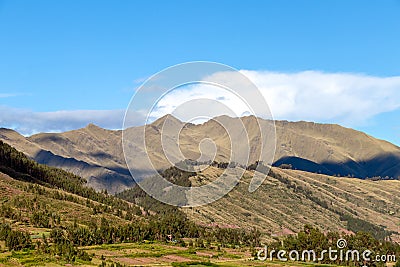 Mountain landscape with fertile valley below steep forests and ancient agricultural terraces at sunset Stock Photo