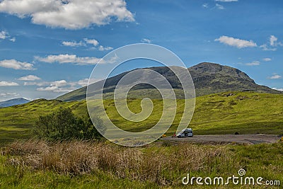 Mountain landscape in the Glencoe area in Scotland, Springtime view mountains with grassland and countryside road in the valley of Stock Photo