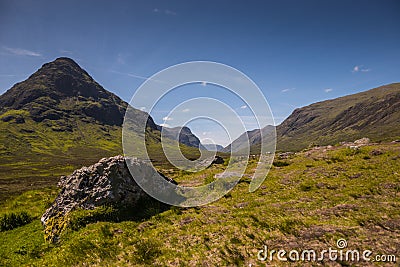 Mountain landscape in the Glencoe area in Scotland, Springtime view mountains with grassland and countryside road in the valley of Stock Photo