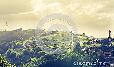 Mountain landscape - Houses and windmills on the mountain - spring green and sunrays - ecological landscape. Stock Photo