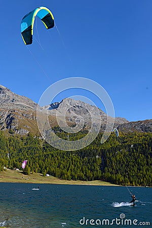 Mountain landscape with a lot of kite surfers and windsurfers moving in a lake Editorial Stock Photo