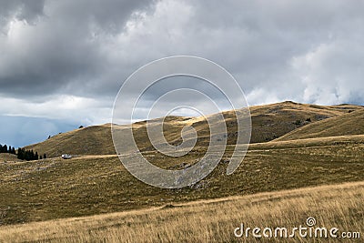 Mountain landscape with pastures and sun spots on top Stock Photo