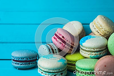 Mountain of macaroons on a turquoise wooden background, a French almond cookie lies on a close-up table. Copy space Stock Photo