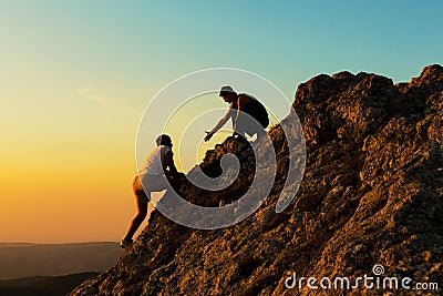 Man Rock Climbing with another Man Helping Stock Photo