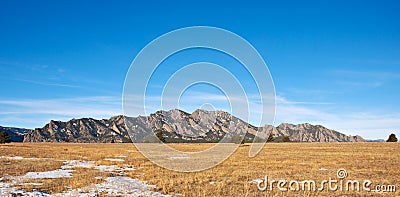 Mountain Panorama with a Grassy Field Stock Photo