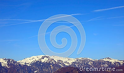 mountain panorama with white chemtrails left by the Arians or by something else According to the conspiracy theory Stock Photo
