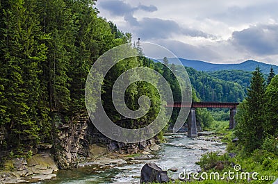 Mountain river with a rapid current of rocks and a bridge Stock Photo