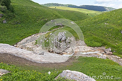 the beginning of the summer season, walks on the mountain slopes, the sources of the mountain river and Stock Photo