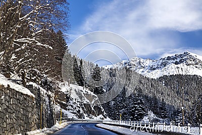 Mountain road, rocks m forest in the snow in the Alps on a Sunny winter day Stock Photo