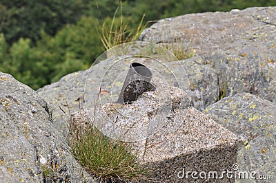 Mountain rocks detail with rusty metallic object Stock Photo