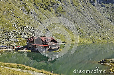 Mountain chalet on the greenwater lake Stock Photo