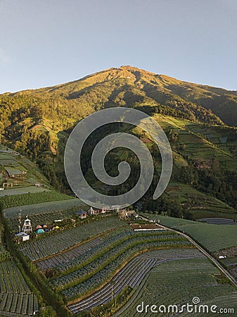 The mountain slopes are full of green vegetable plantations and there are tourist spots on it. Stock Photo