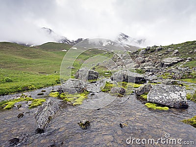 Mountain stream and snow capped peak near col de vars in haute provence Stock Photo